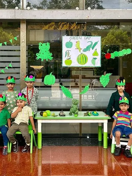 A class of preschoolers wearing green crowns they made themselves, celebrating Green Day with creative flair.