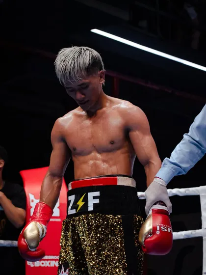 A moment of reflection for a fighter after a tough round. The physical and mental demands of the sport are immense.