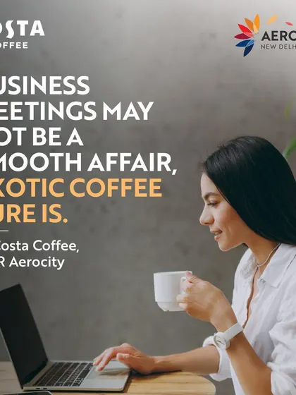 A woman works on her laptop while enjoying a cup of coffee. The caption notes that while business meetings may not be smooth, exotic coffee from Costa Coffee sure is.