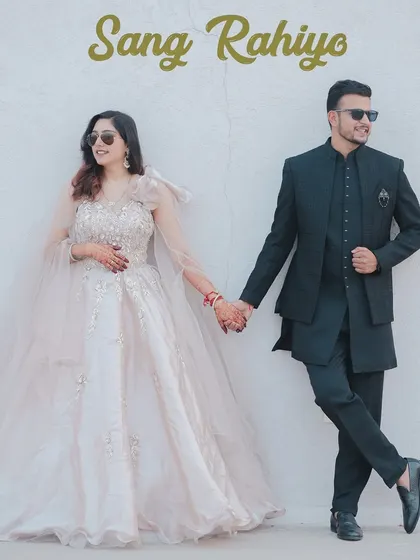 A high-fashion, elegant portrait with the couple dressed in glamorous attire. The simple background and confident pose create a look worthy of a magazine cover.
