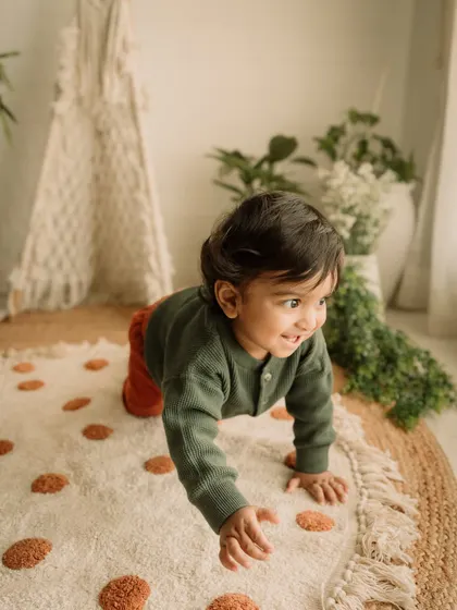 A shot of a toddler on the move, crawling across the textured rug with a look of happy determination.