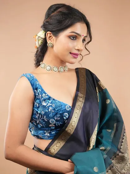 A simple kundan choker is the perfect accessory for this richly embroidered blue velvet blouse, adding a touch of sparkle without overwhelming the design.