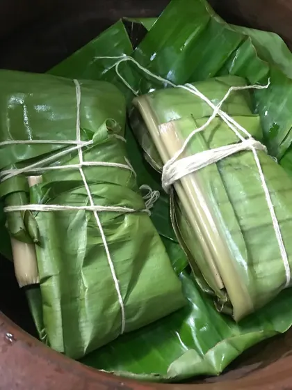 Freshly wrapped Pollichathu parcels, tied with string and ready for the pan. This traditional method ensures all the flavors of the spices and the juices of the fish are sealed inside.