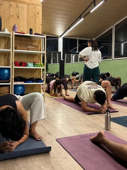 A student in a deep lizard lunge, working on hip flexibility. Our instructors guide students to find their edge safely.