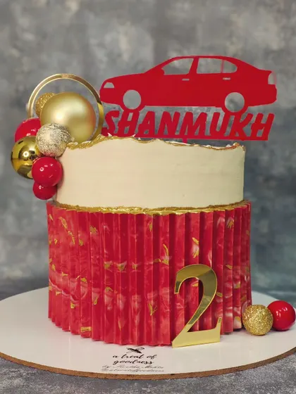 A full view of the red and white car-themed cake. The contrast between the smooth top tier and the textured bottom tier creates a visually interesting and modern design.
