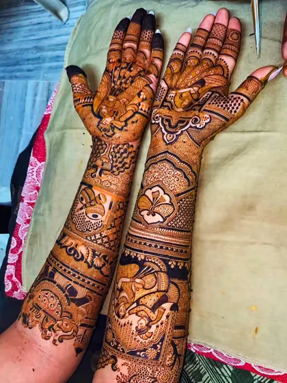 This design shows two different styles on each hand. One is a classic Indian design with figures, while the other is a modern Arabic-inspired floral pattern.