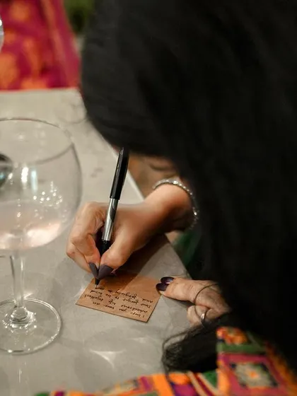 A guest writes a message of love for the couple, a small, interactive detail that adds a personal touch to the wedding.