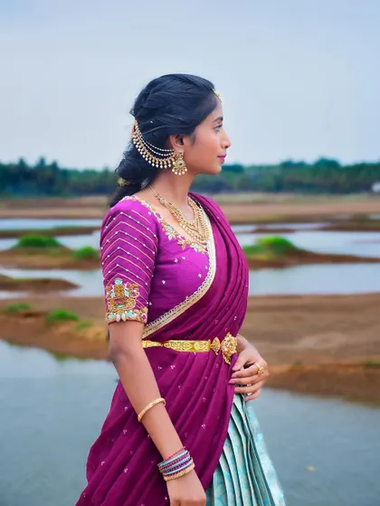 A side profile of the mint and magenta half saree, showing off the detailed sleeve embroidery.