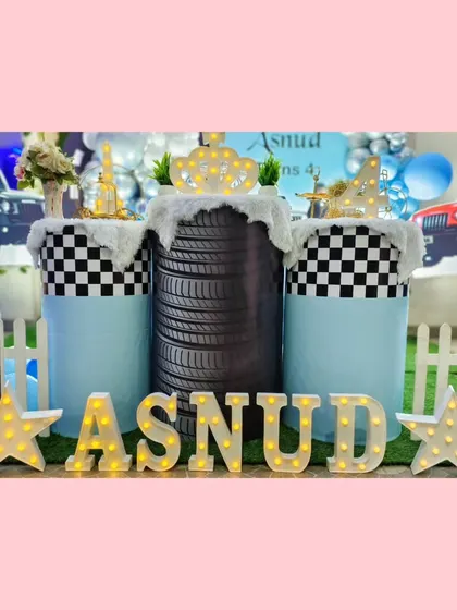 A close-up of the creative pedestals at the Thar party, including one made from a real tire and others with checkered flag patterns.