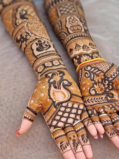 A beautiful bridal design featuring swans, peacocks, and a Ganesha motif. The combination of these auspicious symbols is perfect for a wedding.