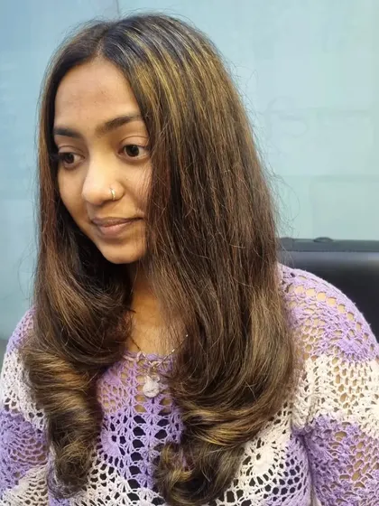 A gorgeous global hair color with highlights. The warm brown and blonde tones blend together perfectly, and the soft curls at the end complete the look.