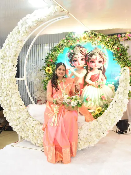 The mom-to-be poses against a beautiful crescent moon backdrop, showcasing her full floral jewellery set and basket.