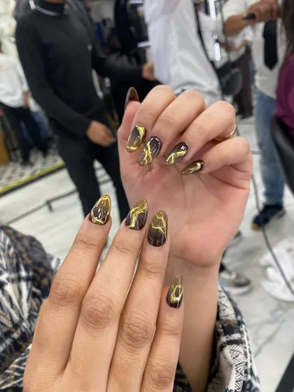 A dramatic and trendy design featuring a black base with a gold liquid marble or "cat-eye" effect, creating a bold and luxurious look.