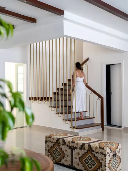 The renovated staircase in the 'Spanish Country Home'. We replaced the original bulky structure with elegant wood treads, micro-topped risers, and a sleek, modern railing with brass-finished vertical bars, transforming it into a central design feature.