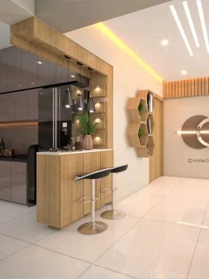 An open kitchen concept with an integrated breakfast counter and bar area. The wood tones and warm lighting make this a very social and inviting space.