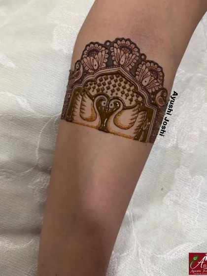 A startup detail of an engagement arm band, featuring two swans inside a traditional arch, symbolizing love and purity.