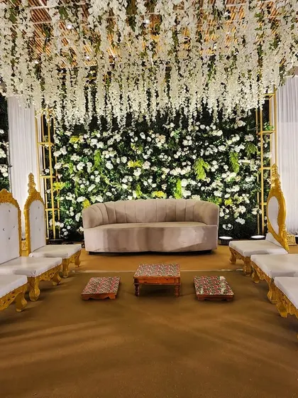 The family seating arrangement on the elegant green floral stage, providing a beautiful and comfortable space for the closest family members.