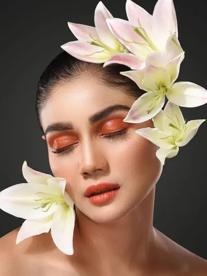 This serene portrait uses soft lighting to complement the delicate white lilies and shimmery orange eyeshadow. It's an example of how I blend natural elements into editorial beauty photography.