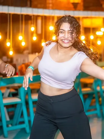A dancer striking a pose with a huge smile. The confidence and joy are infectious.