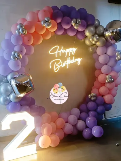 A beautiful sunset-colored balloon ring in shades of orange, purple, and pink for a second birthday.