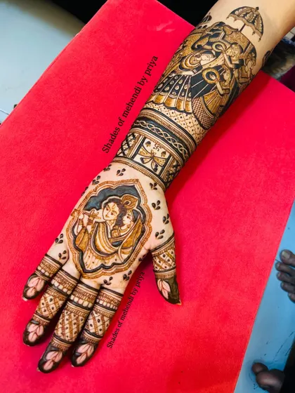 A full view of the hand and arm, showing how the Radha Krishna portrait on the palm connects seamlessly with the royal procession design on the arm.