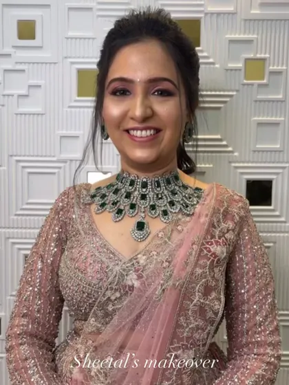 This engagement bride looks absolutely radiant. Her stunning green and silver necklace is the centerpiece, complemented by soft pink makeup and an elegant updo.