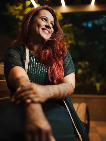 A candid, smiling portrait of the bride, basking in the glow of the evening and her Mehendi celebration.