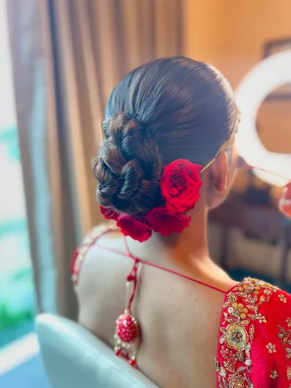 A side view of the braided rose bun, showing the intricate details of the braid and the placement of the flowers.
