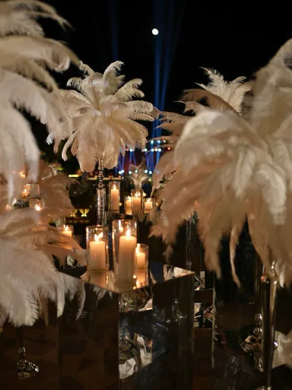 Plumes of white ostrich feathers and mirrored pedestals added to the decadent 1920s glamour of the Sangeet decor.