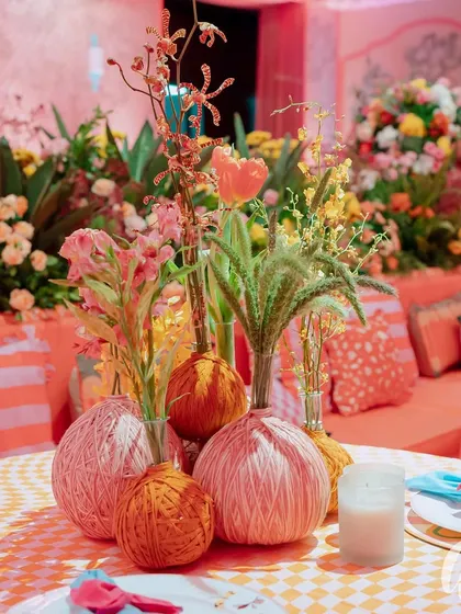 A close-up of our table centerpieces, where we mixed fresh flowers with unique yarn-wrapped spheres. This shows our focus on texture and custom details to make every element of the decor unique and interesting.