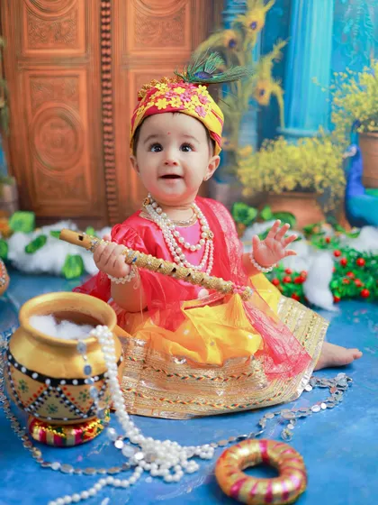 A tiny Radha, looking absolutely charming. The soft colors and delicate jewelry create a portrait that is both divine and incredibly sweet.