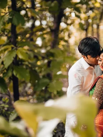 A tender embrace in the woods. This post-wedding or pre-wedding shot captures a quiet, intimate moment in a natural setting.