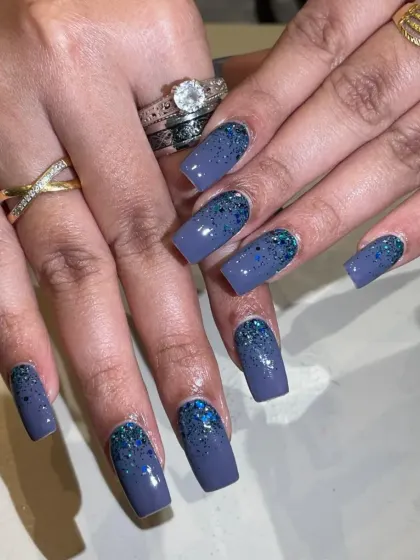 A sophisticated dusty blue set on square nails, with a beautiful cascading glitter effect from the cuticle.