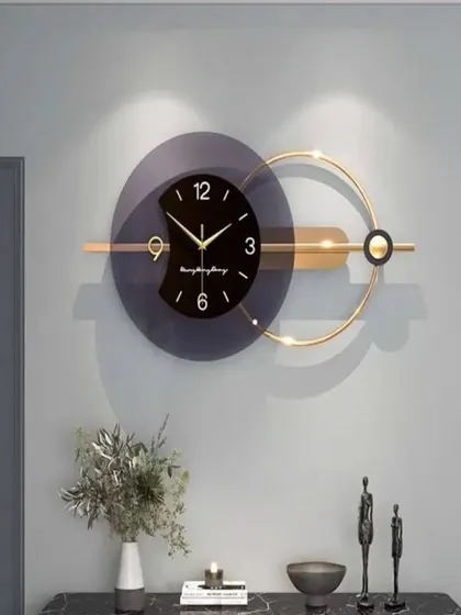 A contemporary design featuring a dark, semi-transparent disc and a golden ring. This imported metal wall clock plays with geometry and balance, making it an ideal statement piece for a modern living or dining room.
