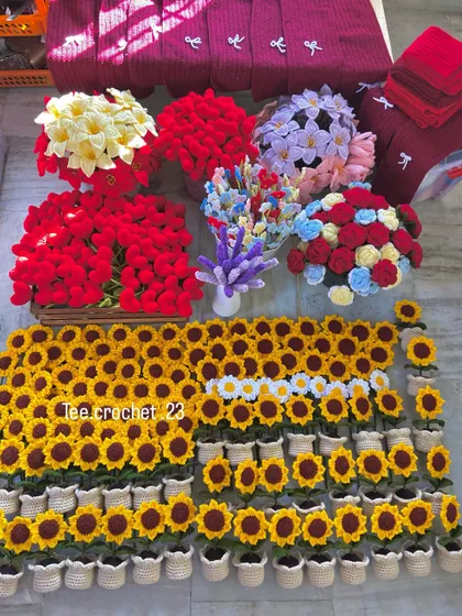 A huge wholesale order laid out, featuring potted sunflowers and large bunches of colorful flower stems.