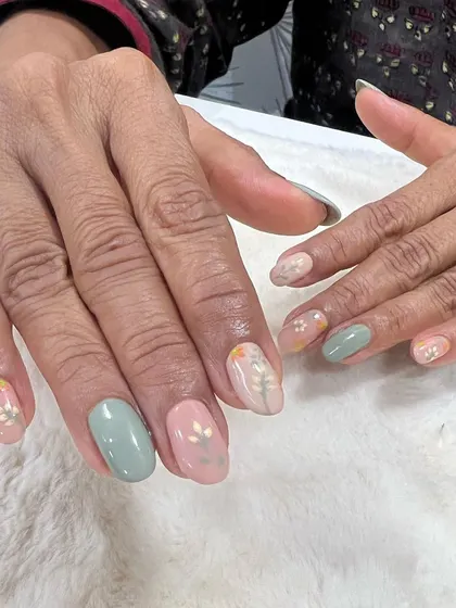Simplicity at its best. This client chose a mix of pastel pink and green gel polish with delicate, hand-painted white floral accents.