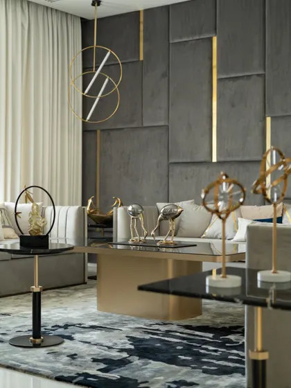 A formal seating area combines a plush grey sofa with gold and brass accents in the lighting and decor, creating an atmosphere of sophisticated luxury.