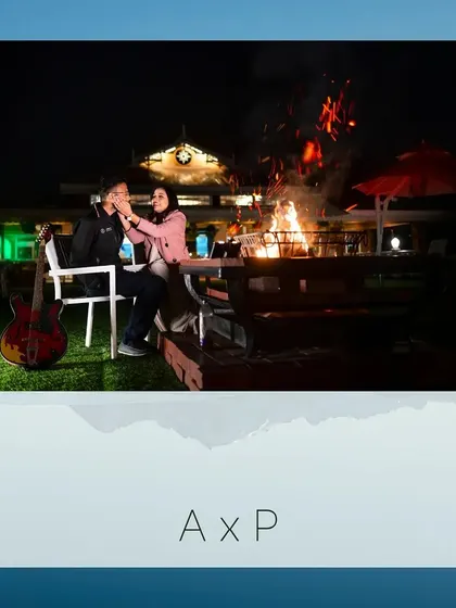 Another beautiful bonfire scene with Akash and Priya. The guitar adds a personal touch, suggesting a story of shared songs and cozy nights together.