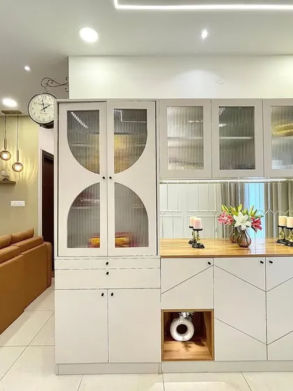 This custom-built crockery unit combines open and closed storage, with unique geometric patterns on the lower cabinets and frosted glass on the upper ones for a modern, elegant look.
