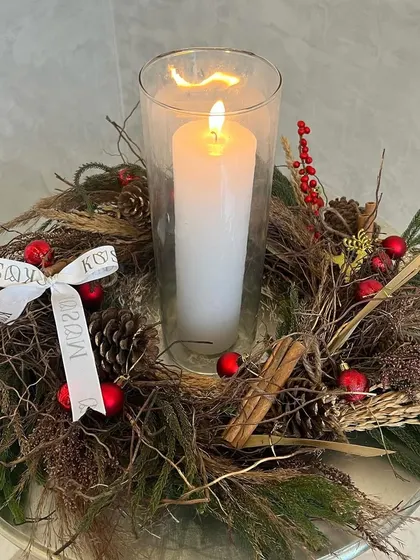 My "Scarlet" wreath is elegant and airy, with reds and browns that evoke a cozy, rustic charm. Here, I've placed a candle in the center, turning it into a beautiful centerpiece for a side table.