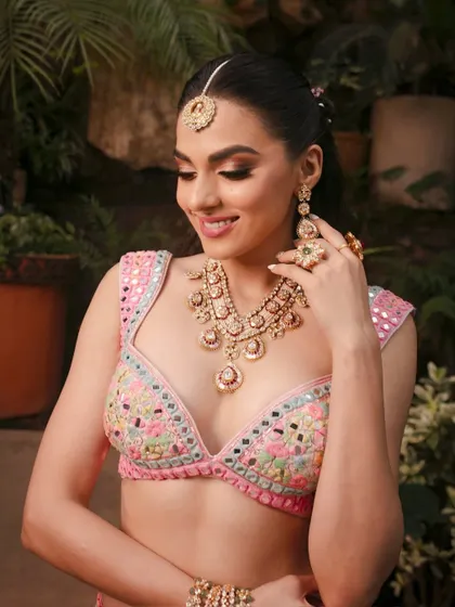 A close-up of the Mehendi look, focusing on the soft smokey eye and the intricate mirror-work blouse.