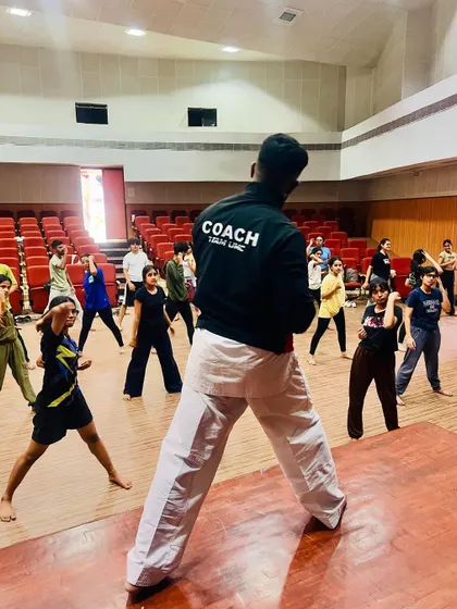 A view from behind the coach, leading the NIFT students in their karate stances.