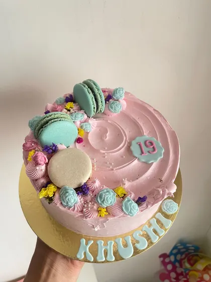 A pretty pink half-kilo cake decorated with macarons and delicate flowers. Perfect for a 19th birthday.