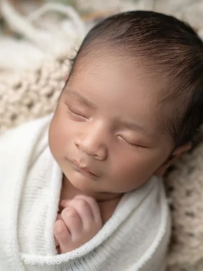 Deep in dreamland. This close-up captures the serene expression of a sleeping newborn, a moment of pure peace.
