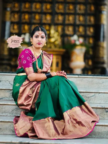 A stunning bride ready for her Varapooje ceremony. The rich green and pink saree is paired with soft glam makeup, creating an elegant and traditional look.