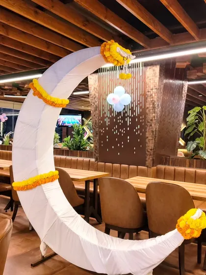 A simple and elegant moon prop decorated with marigolds for a baby shower.