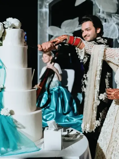 The cake-cutting ceremony is a classic moment, elevated here with a stunning multi-tiered cake that complements the glamorous reception theme.