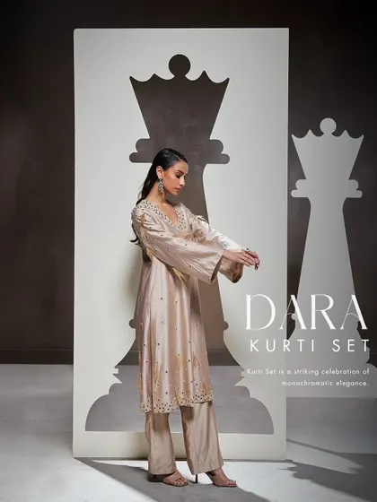 My Dara Kurti Set is a celebration of monochromatic elegance. This fusion silhouette features a stunning kurti and sharara adorned with exquisite hand embellishments.