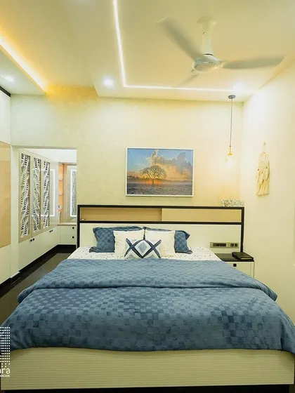 A contemporary bedroom design featuring a sleek white and wood bed with an integrated headboard and wardrobe. The subtle wallpaper and modern art piece complete this stylish and functional space.