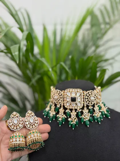 This image shows the choker with its matching jhumka earrings held in hand, giving a clear view of the complete set you can rent.